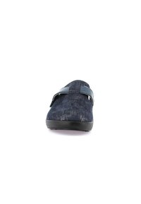 Scarpa slip-on blu navy con tomaia in tessuto texture, caratterizzata da una fascia a contrasto e una suola in gomma nera. La vista frontale mostra un design con punta arrotondata.