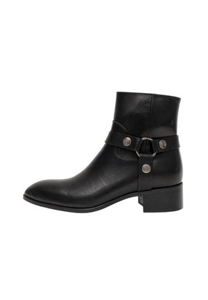 Stivaletto nero in pelle con tacco basso a blocchetto, punta arrotondata e cinturino decorativo con borchie metalliche e dettaglio ad anello sul lato.