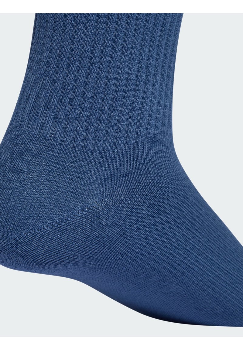 Blaue Baumwollsocke mit gerippter Textur, die über eine verstärkte Ferse und Spitze für Langlebigkeit verfügt. Das Design ist knöchellang.