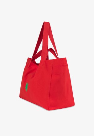 Červená plátenná taška s dlhými červenými popruhmi. Na jednej strane má vyšívaný zelený kvetinový motív. Pevná konštrukcia s priestranným vnútrom.