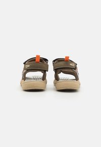 Brune sandaler med oransje accenter og svarte stropper. Har en teksturert såle og justerbare bakstropper for en sikker passform.