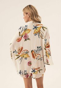 Lekki, paskowany kimono z kolorowym nadrukiem owoców i kwiatów. Miękka tkanina, luźny krój i szerokie rękawy.