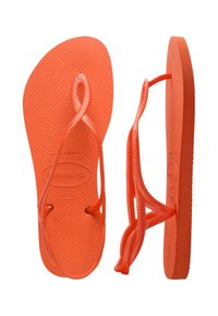 Tongs Havaianas orange vif, vues de dessus et de côté, avec une semelle texturée et des brides simples.