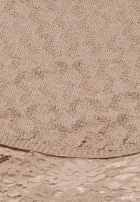 Huidkleurige stof met een gemêleerd herringbone-patroon, bedekt met ingewikkelde bloemenkantdetails, wat een gelaagd uiterlijk creëert.