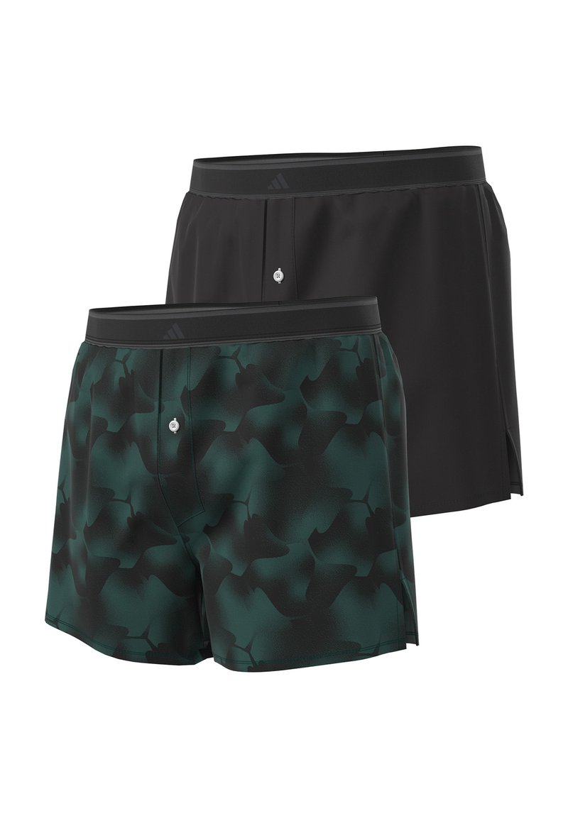 Twee paren shorts: één zwart en één donkergroen met een camouflagepatroon. Beide hebben een elastische tailleband en een knoopdetail.