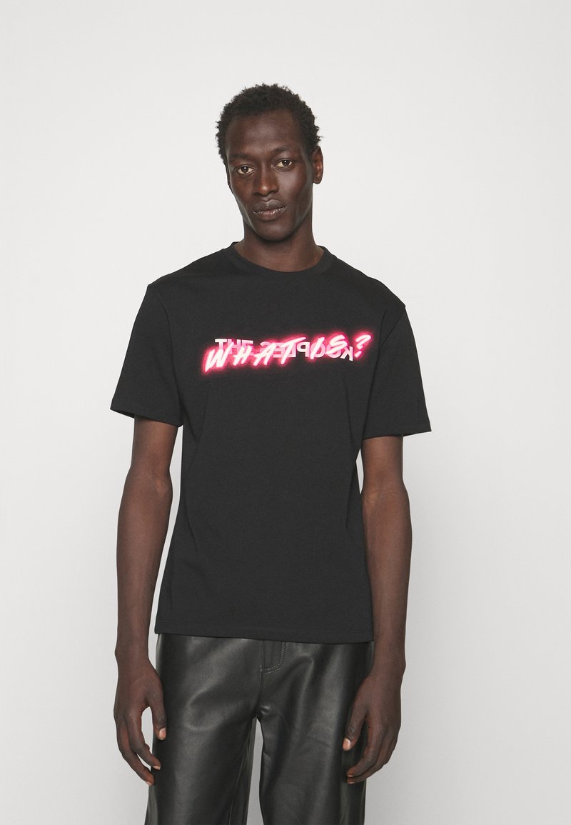 Black cotton t-shirt with short sleeves, featuring bold, neon-style text "WHAT?!" across the chest. Simple, relaxed fit design.
