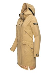 Beige waterproof jacket with a hood, front zip, multiple pockets, and adjustable drawstrings; features a patterned inner lining and black accents.