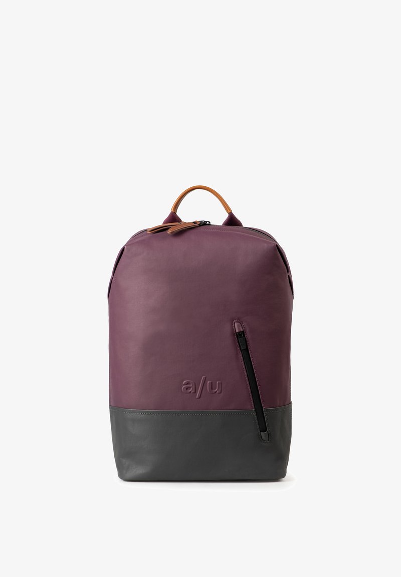 Lila Leder-Rucksack mit einem grauen unteren Abschnitt, ausgestattet mit einem oberen Tragegriff, einer Reißverschlusstasche und einem geprägten Logo auf der Vorderseite.