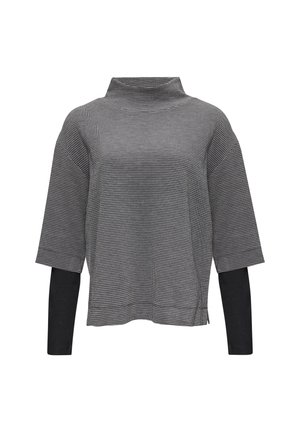 Black and white houndstooth-patterned top with a high neckline, drop shoulders, and three-quarter sleeves, featuring a solid black underlayer.