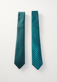 Două cravate teal una lângă alta; una este solidă cu un model texturat, cealaltă are un design cu buline, cu buline albe pe un fundal texturat.
