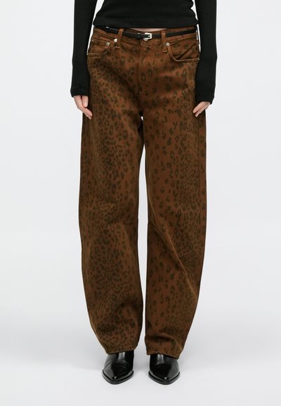 Calças castanhas de perna larga com padrão de estampa de leopardo em verde escuro, com cinco bolsos e um cinto preto. O tecido apresenta uma textura suave.