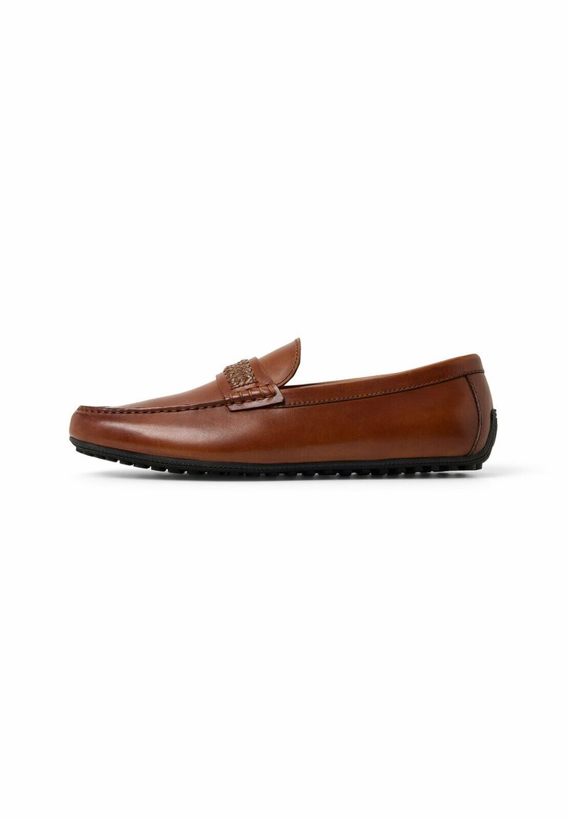 Mocasín de cuero marrón con un diseño cosido, punta redonda y un acabado suave. Presenta un acento texturizado en el empeine y suela de goma.