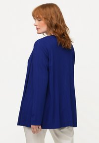 Blauw geribde langärmige top met een ontspannen pasvorm, voorzien van een ronde halslijn en een vloeiende silhouet, aangevuld met subtiele textuur.
