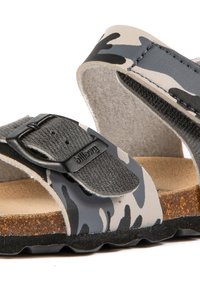 Sandales à motif camouflage avec des sangles grises et noires, semelle en bouleau, boucle réglable et semelle texturée pour une meilleure adhérence.