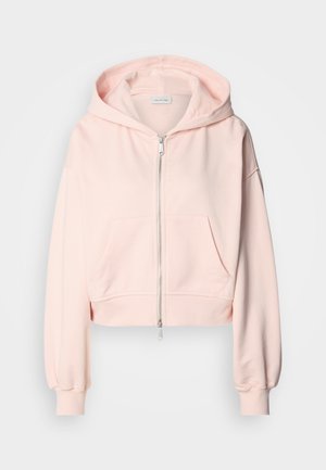 Sweatshirt cor-de-rosa cortado, feito de tecido macio, com fecho na frente, dois bolsos frontais e capuz com cordão e mangas franzidas.