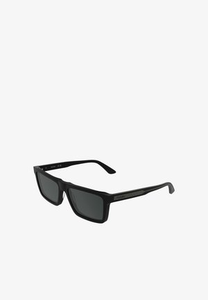 Occhiali da sole rettangolari neri con lenti scure. Dettagli testurizzati sulle aste. Finitura opaca sulla montatura. Design elegante.