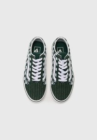 Grønne mønstrede sneakers med hvide snørebånd, tekstureret overdel og hvid sål. Har et logo på tungen og indviklede design henover.
