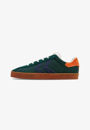 Zielone tekstylne sneakersy z granatowymi akcentami, białymi sznurowadłami, pomarańczowym językiem na pięcie i brązową gumową podeszwą. Zawierają wyraźny wzór chevronu po boku.
