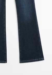 Wide-leg donkerblauwe spijkerbroek met een schone afwerking, gedetailleerde stiksels en een gladde textuur. Heeft een rechte snit en geen zichtbare versieringen.