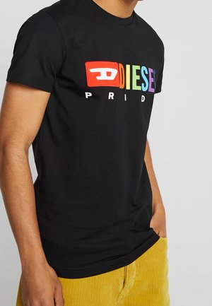 T-shirt noir en coton arborant un logo coloré "DIESEL PRIDE", avec le mot "DIESEL" en lettres majuscules et aux couleurs arc-en-ciel sur un fond rectangulaire rouge.