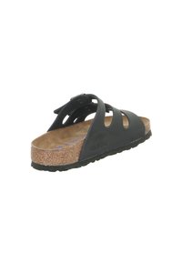 Zwarte rubberen slidesandalen met drie uitsparingen. Korken voetbed, gestructureerde zool en een gespsluiting op de bovenste band.