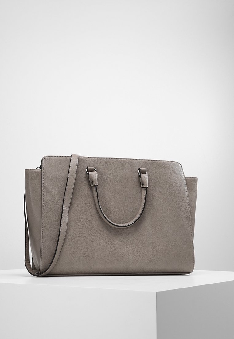 Šedá kožená kabelka se strukturovaným designem, dvojitými horními uchy a odnímatelným ramenním popruhem. Hladký povrch bez viditelných vzorů.