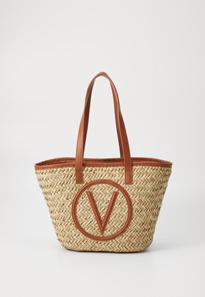 Vævet stråtotetaske med brune læderdetaljer, prydet med et stort cirkulært V-logo. Åben-top design med to robuste håndtag.