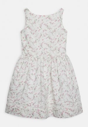 Robe sans manches blanche avec un motif floral en rose et vert, présentant une taille froncée et un tissu texturé. Détail d'ourlet simple.