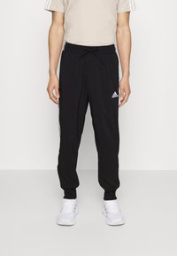 Melni sporta bikses ar aukliņu viduklī, sānos ar baltām svītrām un Adidas logotipu kreisajā pusē. Izgatavotas no viegla auduma.