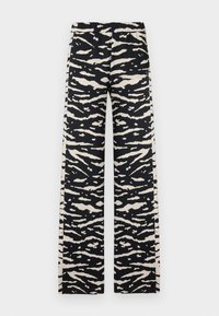 Pantalon large à rayures zébrées noir et crème avec une taille élastique, doté de poches et d'une texture de tissu lisse et léger.