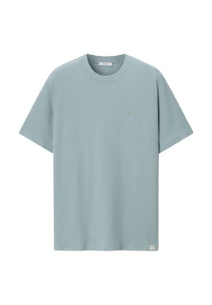 Hellblaues T-Shirt mit kurzen Ärmeln und Rundhalsausschnitt, mit kleinem gesticktem Logo auf der linken Brustpartie und einem Stofflabel nahe dem Saum.