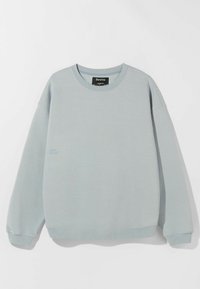 Lichtblauwe sweatshirt van zachte stof, met een ronde hals en geribbelde manchetten. Een klein bedrukt detail aan de voorkant voegt interesse toe.