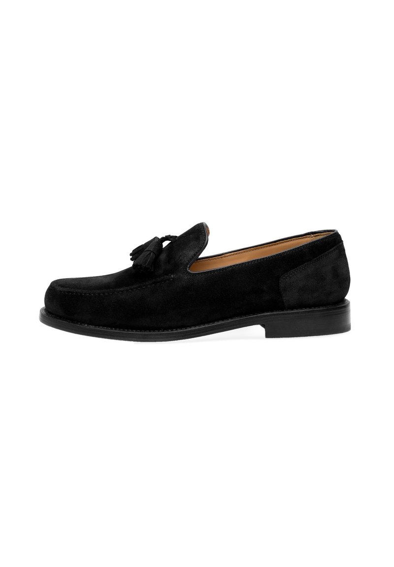 Zwarte suède loafers met een ronde neus, voorzien van een kwastdetail en een contrasterende zwarte rubberen zool. Strak ontwerp, gestructureerd oppervlak.