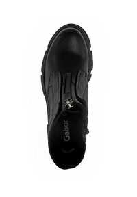 Black ankle boot with a smooth leather upper, textile accents, decorative zippers, and a sturdy rubber sole. Interior branding visible.