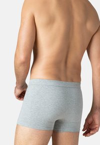 Boxers en coton gris avec une texture douce, présentant un design de taille simple. Aucun motif ni détail matériel visible.