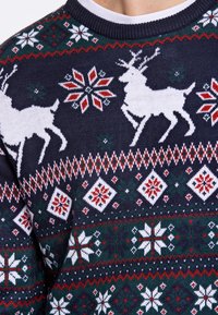 Pulôver de malha azul-marinho com padrões de renas brancas, flocos de neve e diamantes em vermelho e verde. Design de gola redonda com tecido texturizado.