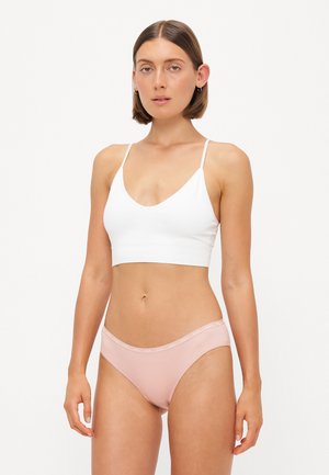 Witte geribde bralette met dunne bandjes, gecombineerd met lichtroze bikini bottoms met een zachte tailleband. Soepele textuur, eenvoudig ontwerp.