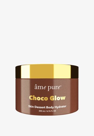 Braunes Glas mit einem goldenen Deckel. Auf dem Etikett steht "Choco Glow Skin Dessert Body Hydrator, 200 ml." Glatte Textur, modernes Design, minimalistische Grafiken.