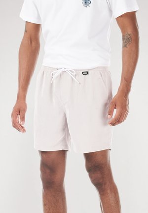 Helle beige Badeshorts aus leichtem, strukturiertem Stoff, mit elastischem Bund und weißem Kordelzug zur Anpassung.