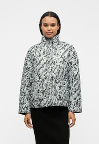 Δεμένο μπουφάν σε ανοιχτό γκρι χρώμα με μαύρα αφηρημένα σχέδια. Διαθέτει ψηλό γιακά, μπροστινές τσέπες και χαλαρή εφαρμογή.