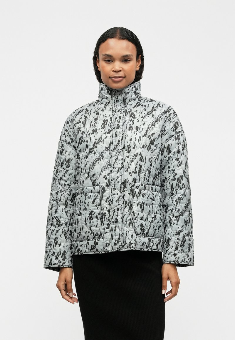 Δεμένο μπουφάν σε ανοιχτό γκρι χρώμα με μαύρα αφηρημένα σχέδια. Διαθέτει ψηλό γιακά, μπροστινές τσέπες και χαλαρή εφαρμογή.