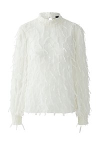 White long-sleeve blouse with a high neck and smocked cuffs. Features textured fabric with multiple delicate, frayed accents throughout.