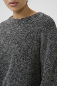 Grijze gebreide trui met een ronde halslijn, voorzien van een gestructureerd, fluffy oppervlak en een dropped shoulder ontwerp voor extra comfort.