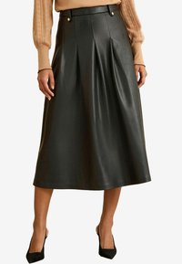 Fekete bőr midi szoknya pliszékkel, magas derékkal és díszes arany gombokkal. Simává tűnt textúra és A-vonalú forma, a vádli közepéig ér.