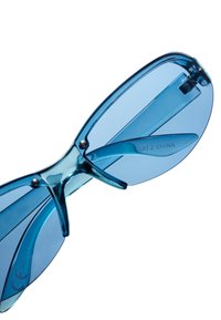 Gafas de sol azules con un marco translúcido, forma ovalada y lentes espejados. Los detalles notables incluyen herrajes plateados y grabados de "CAT.2 CHINA".