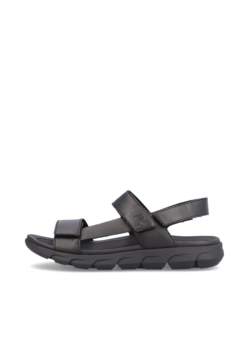 Sandale noire avec des sangles réglables en Velcro, une semelle intérieure rembourrée et une semelle en caoutchouc texturé conçue pour le confort et la stabilité.