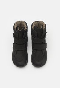 Bottes en cuir noir avec deux sangles Velcro, surfaces texturées, doublure en fourrure, et bouts ronds. Design mi-hauteur adapté aux temps froids.