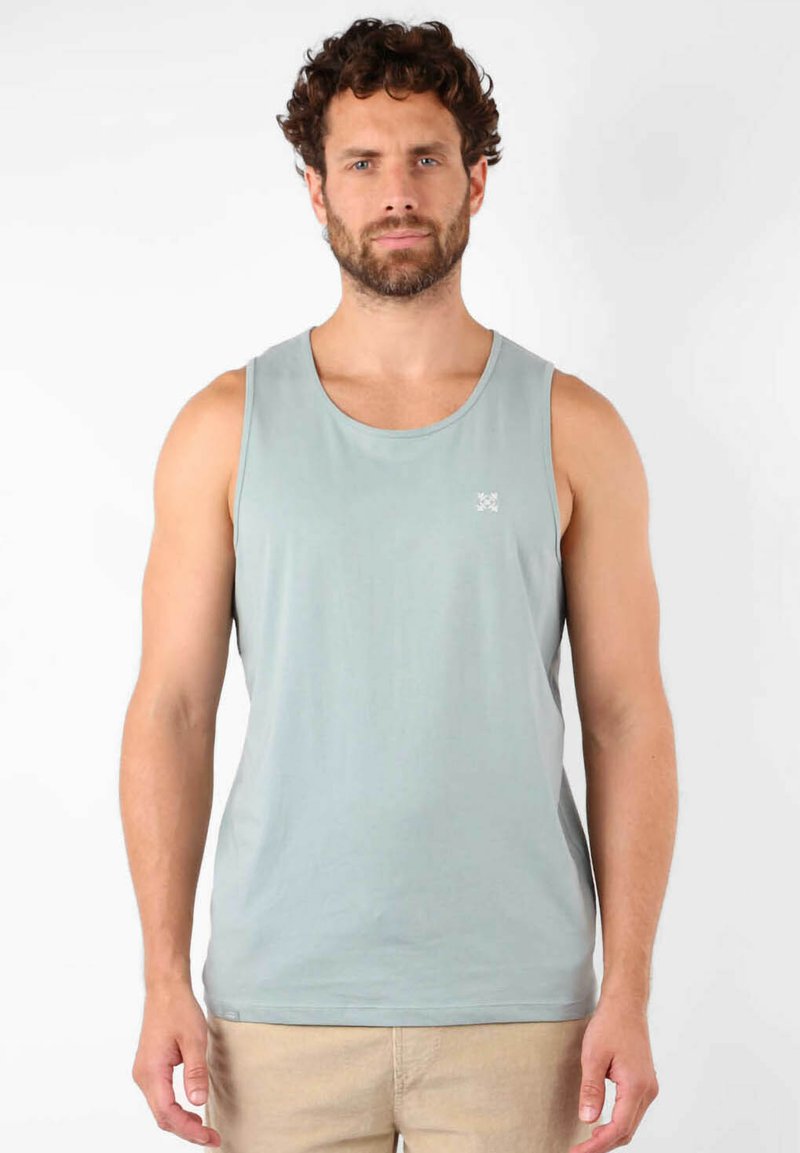 Débardeur sans manches bleu clair en tissu doux, avec un col rond et un petit logo sur la poitrine. Design simple et épuré.