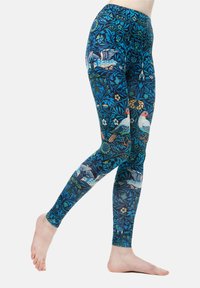 Kék virág- és madármintával díszített leggings, precíz részletezéssel. Rugalmas anyagból készültek, sima, testhez álló textúrával.