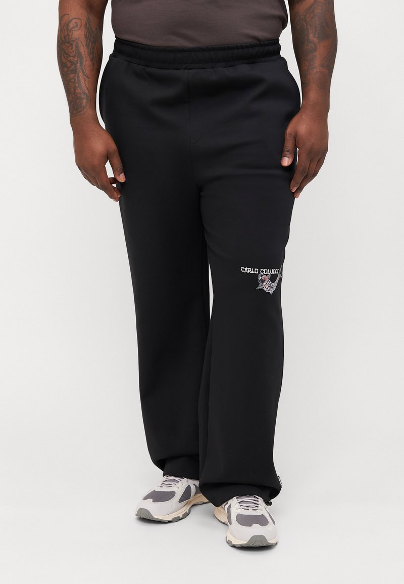 Black sweatpants with an elastic waistband, featuring an embroidered logo on the left thigh, made of soft fabric, with a relaxed fit.